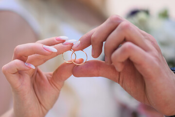 wedding rings in the hands of the bride and groom