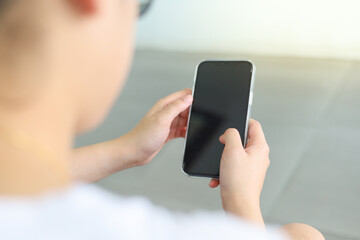 A woman sitting in a restaurant looks at the screen of her cell phone and reads a message. Woman hands with smartphone for online shopping and payment. Shopping service on online web. Spending money.