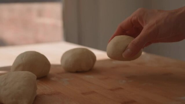 Woman rolling out flatbread dough on a wooden table
