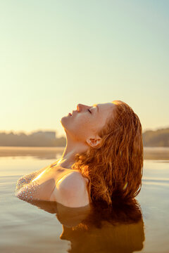 Beautiful redhead woman as mermaid with giant seashell