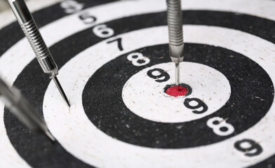 The dart game sticks out in the center of the red target an accurate hit to the target
