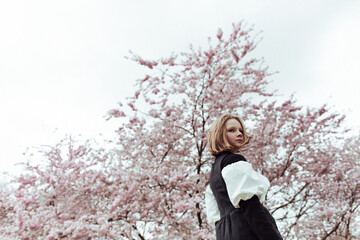 Girl standing near blooming tree