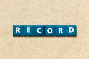 Tile alphabet letter in word record on wood background