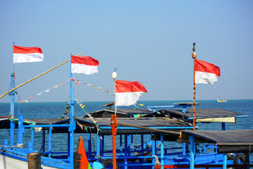 Indonesia's red and white flag flying on a fishing boat. The large red and white Indonesian flag...