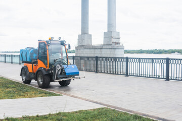 small tank truck for cleaning paths and watering plants on the city embankment