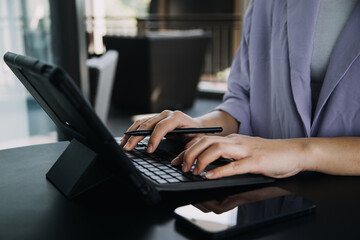 Asian Business woman using calculator and laptop for doing math finance on an office desk, tax, report, accounting, statistics, and analytical research concept