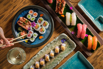 Person taking maki sushi roll from plate © ADDICTIVE STOCK CORE