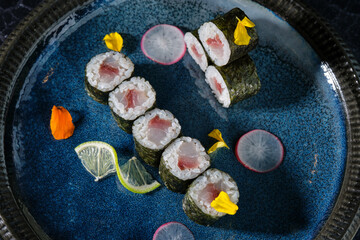 Obraz na płótnie Canvas Delicious sushi rolls on blue plate