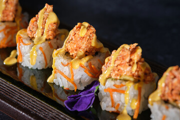 Delicious sushi served on wooden plate in restaurant