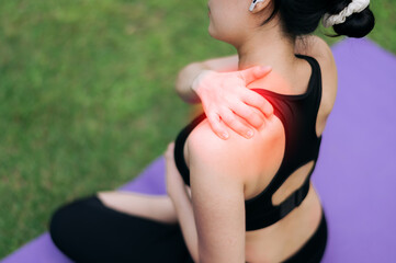 Woman jogger. young 30s asian female wearing black sportswear holding her shoulder pain after...