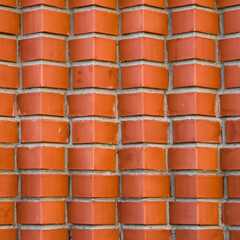 Individual design of red brick wall from diagonally angular bricks close up. Geometric background...