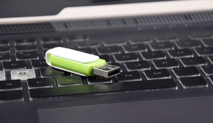 USB memory stick or flash drive on the keyboard of an open laptop.