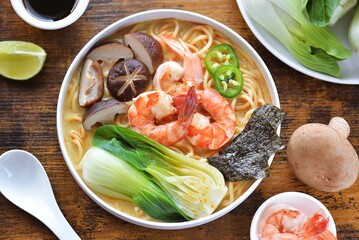 Asian spicy soup with noodles, shiitake mushrooms, shrimp and bok choy. Top view.