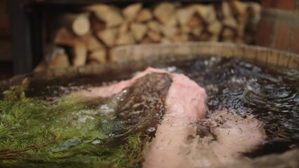 Witness the invigorating contrast of temperature at the spa center as an athletic man fearlessly plunges into a pot filled with cold water after a steamy sauna session, reaping rejuvenating benefits 