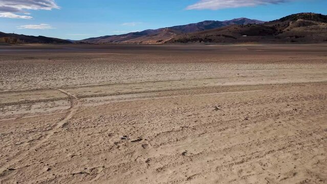 Aerial pull back of dry, cracked lake bed in the arid western United States as drought continues.