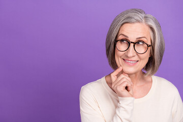 Photo of funny pensioner lady interested look empty space tricky face bite lower lip sly clever...