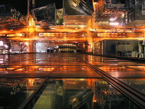 An breathtaking view of a city at night (Chicago, Illinois). The city is bathed in lights, and the streets are teeming with activity and full of energy. The traffic lights create a dazzling display.