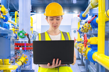 Woman employee of chemical factory. Girl industrialist with laptop. Woman stands in room with...