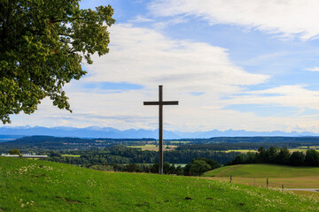 Alpine view over meadows and field paths towards the Alps near Reichling in Bavaria on a summer day with blue sky and light clouds