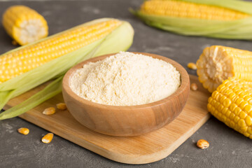 Corn flour with fresh cobs on concrete table