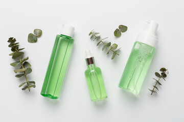 Herbal face care products on color background, top view