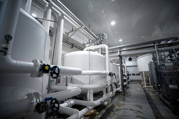 Carbon vertical steel tanks whites and pipes with pressure meter in equipment tank chemical cellar at the with carbon steel