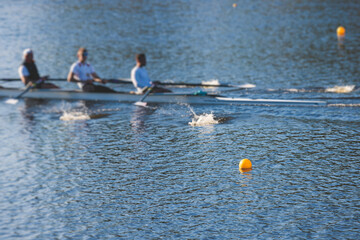 Group of rowing team athletes sculling during competition, kayak boats race in a rowing canal, regatta in a summer sunny day, canoeing water sports team training in a river © tsuguliev