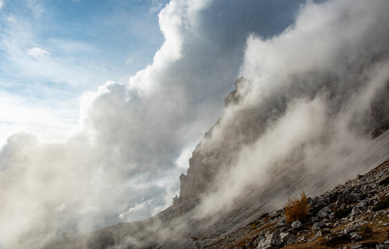 Cloudy fogy sky mountain peaks covered in mist in the morning. Dolomite rocky mountains Italy