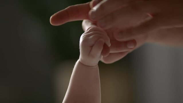 Father and newborn baby. Hand bond. Hand in hand.