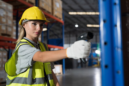 Caucasian female warehouse worker working at work scanning barcode on products boxes for checks stock, inventory with tablet on shelf pallet in the storage warehouse