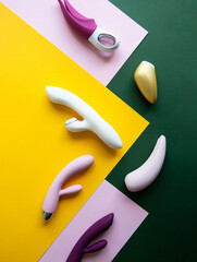 Collection of different types of sex toys on a pink, green and yellow background. - 633455928
