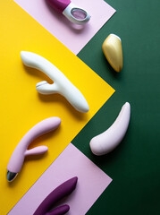 Collection of different types of sex toys on a pink, green and yellow background. - 633455932