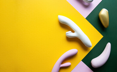 Collection of different types of sex toys on a pink, green and yellow background. - 633455935