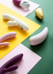 Collection of different types of sex toys on a pink, green and yellow background. - 633455942