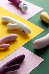 Collection of different types of sex toys on a pink, green and yellow background. - 633455946
