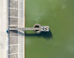 aerial drone view of concrete wall of hydro dam with pump on the lake 