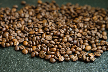 Pile of coffee beans on black granite table
