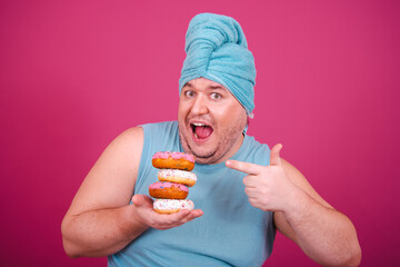 Funny fat man enjoys life and eats donuts. Fitness in the early morning.