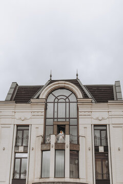 bride on the balcony of the hotel in a white robe with a veil, free space, vertical photo. On your wedding day
