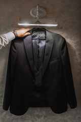 a man's jacket hangs on a hanger, a businessman man takes it in his hands and prepares for a meeting