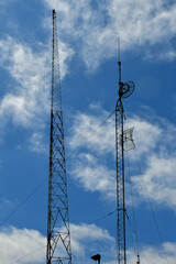 AM broadcast tower and a secondary tower with municipal communications pole antenna and dishes 