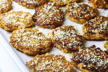 Sweet potato fritters topped with parmesan. Plant based food. Carrot cutlets with herbs and parsley. Batat fries or baked pumpkin parmigiano fritters. Sweet potato pancakes, veggie food