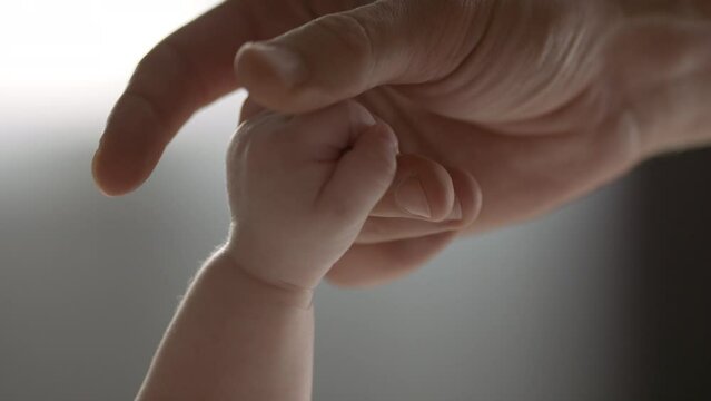 Father and newborn baby. Hand separation.