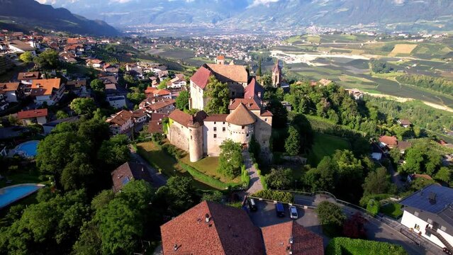 Schenna Scena South Tyrol Italy. cinematic drone view Medieval Castle and Alps Mountains View near Merano. Traditional Village and vineyards in Trentino Alto Adige. Scenic Alpine Landscape 4k