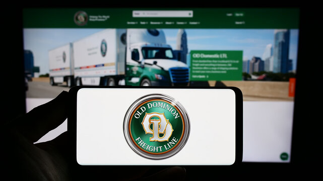 Stuttgart, Germany - 08-02-2023: Person holding smartphone with logo of US company Old Dominion Freight Line Inc. (ODFL) on screen in front of website. Focus on phone display.