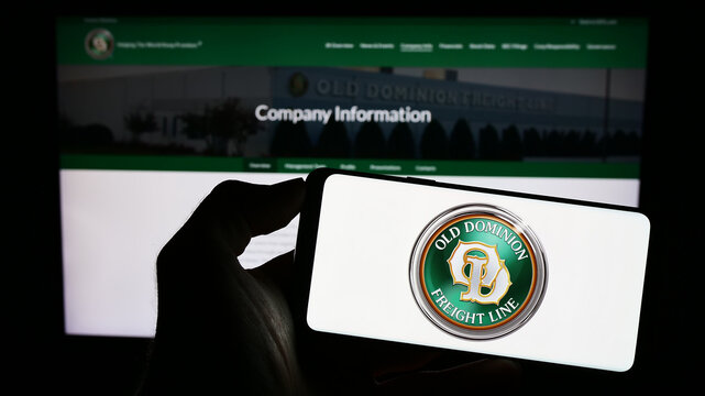 Stuttgart, Germany - 08-02-2023: Person holding cellphone with logo of US company Old Dominion Freight Line Inc. (ODFL) on screen in front of webpage. Focus on phone display.