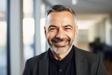 Naklejka premium Middle aged businessman of latin ethnicity smiling in a modern office