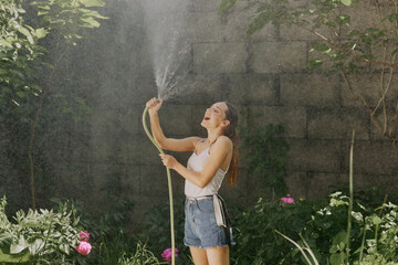 girl enjoying water in the heat of summer in the garden