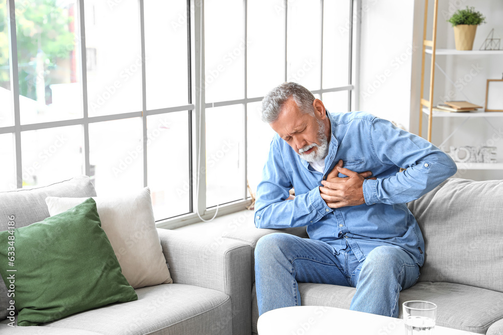 Wall mural mature man having heart attack at home