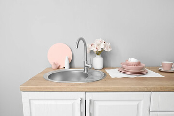Kitchen counter with clean dishes, sink and orchid flowers